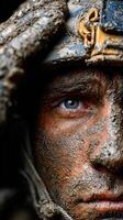 Soldier with mud-covered face gazes intensely while wearing a helmet during military training in challenging conditions photo
