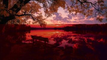 Sunset casts vibrant colors over serene lake with bench reflecting autumn foliage photo