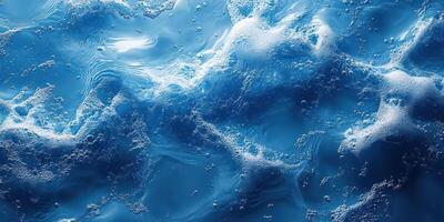 Dynamic water surface with bubbles reflecting light in a deep blue hue during bright daylight photo