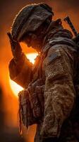 Soldier saluting during sunrise in frosty conditions with glowing orange backdrop photo