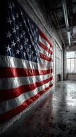 Large American flag displayed on a wall in an industrial style room with polished concrete floor and large windows letting in natural light photo