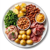 A plate with various foods including meat, beans, potatoes and peas photo