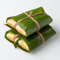 Three wrapped pieces of banana leaf wrapped in string photo