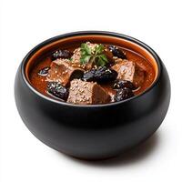 A bowl of meat and dates on a white surface photo