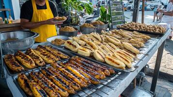 A man is standing in front of a grill with food photo