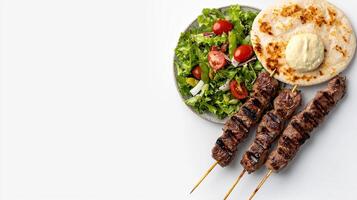 A plate with meat skewers and a pita bread photo