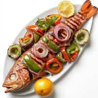 A fish is on a plate with vegetables and a lemon photo