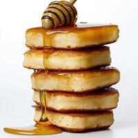 A stack of pancakes with syrup and honey photo