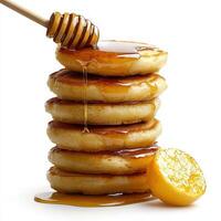 A stack of pancakes with honey and a wooden spoon photo