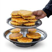 A person holding a stack of pancakes on a tray photo