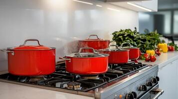 Red pots on a stove top in a kitchen photo