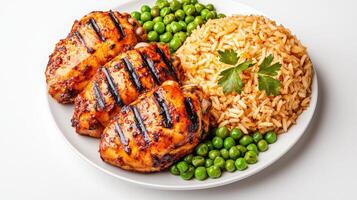 Grilled chicken with rice and peas on a white plate photo