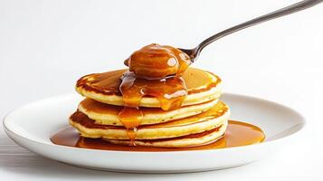 A stack of pancakes with syrup and a spoon photo