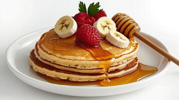 A stack of pancakes with bananas, raspberries and honey photo