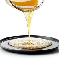 A glass of syrup being poured into a bowl photo