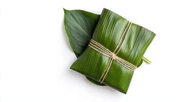 Two green leaves wrapped in string on a white surface photo