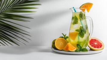 A pitcher of lemonade with oranges and mint leaves photo