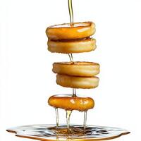 A stack of pancakes being drizzled with syrup photo
