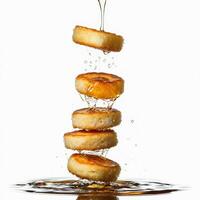 A stack of pancakes being poured with syrup photo
