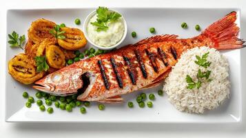 Grilled fish with rice and peas on a white plate photo