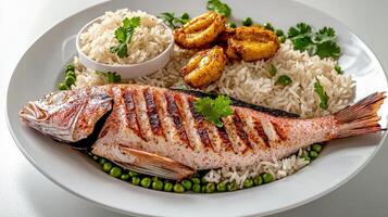A plate of fish and rice with peas and a side dish photo