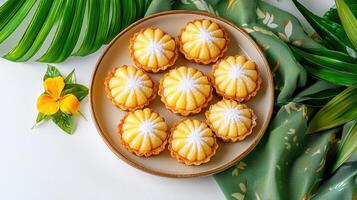 A plate of lemon meringue tarts on a green cloth photo