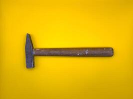 Rusty hammer on yellow background. Builder Tool. Flat lay. Top view, copy space. photo