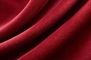 Red velvet fabric forming soft folds, luxurious texture close up photo