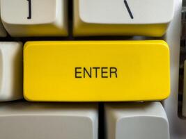 Large yellow Enter button on mechanical white keyboard for programmers with gray shades and red switches, flay lay, copy space photo