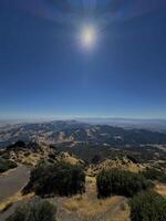 View of the foothills of Mount Diablo from the top of the mountain itself, in the summer with bright sun and blue sky in the background photo