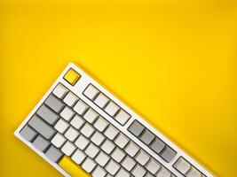 A top view of keyboard without letters on an empty yellow space on a background, for technology concept. Copy space. photo