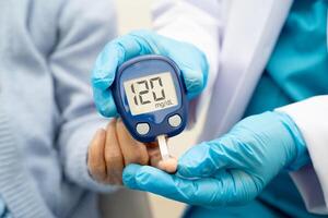 doctor using digital glucose meter for check sample blood photo