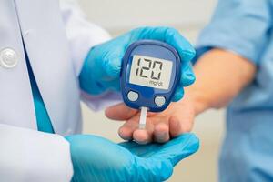 doctor using digital glucose meter for check sample blood sugar level photo