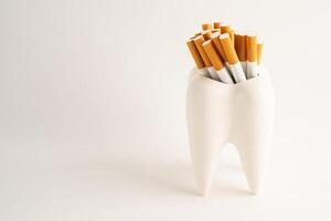 Cigarette with teeth isolated on white background with copy space, No smoking, damage the health of your teeth. photo