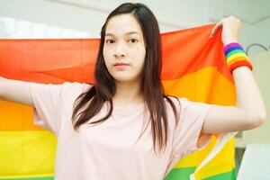 Asian couple woman with LGBT rainbow flag. photo