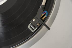 pickup stands on vinyl record, close-up, copy space photo