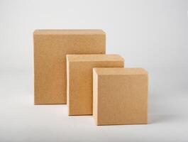 Three square craft boxes of different sizes stand on a white background, mockup, copy space photo