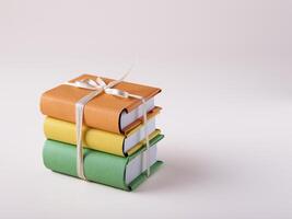 a stack of mini books in bright covers tied with a satin ribbon, on a white background, space for text photo