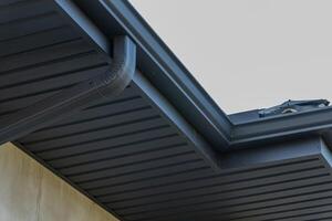 Close-up view showcases a contemporary roof edge with a smooth finish, highlighting architectural details in bright sunlight photo