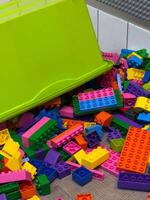 Brightly colored plastic building blocks are scattered across the floor, inviting children to build and explore their creativity photo