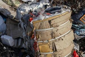 Various materials are stacked together in a recycling site, showcasing the improper disposal of waste in an urban area during daylight photo