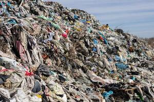 A large mound of waste is visible in a landfill, filled with various types of discarded materials, showcasing environmental pollution photo