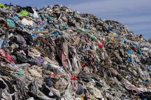 Numerous layers of garbage and discarded materials stack up at a landfill, showcasing the heavy pollution and environmental impact photo