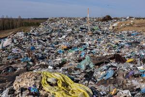 A sprawling landfill area is covered in trash, plastic waste, and debris, highlighting critical pollution challenges faced by ecosystems today photo