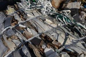 Compacted waste materials are securely bound with straps at a landfill site, highlighting the challenges of pollution and waste management photo