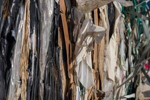 Layers of various recyclable materials are stacked together in a facility during the day, showcasing different textures and colors photo