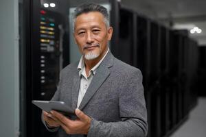 Confident IT manager using tablet in server room. photo