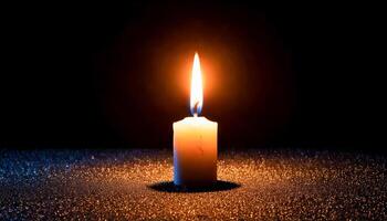 Single candle with a bright, tall flame casting a warm glow on a dark, glittering surface. Deep black background. Evokes a sense of peace, warmth, and focused light in darkness. photo
