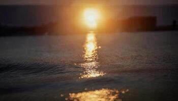 A glowing sun rising over a calm ocean, with golden light photo