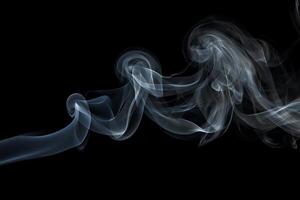 Abstract swirling wisps of elegant smoke gracefully move across a black background creating an artistic and ethereal visual photo